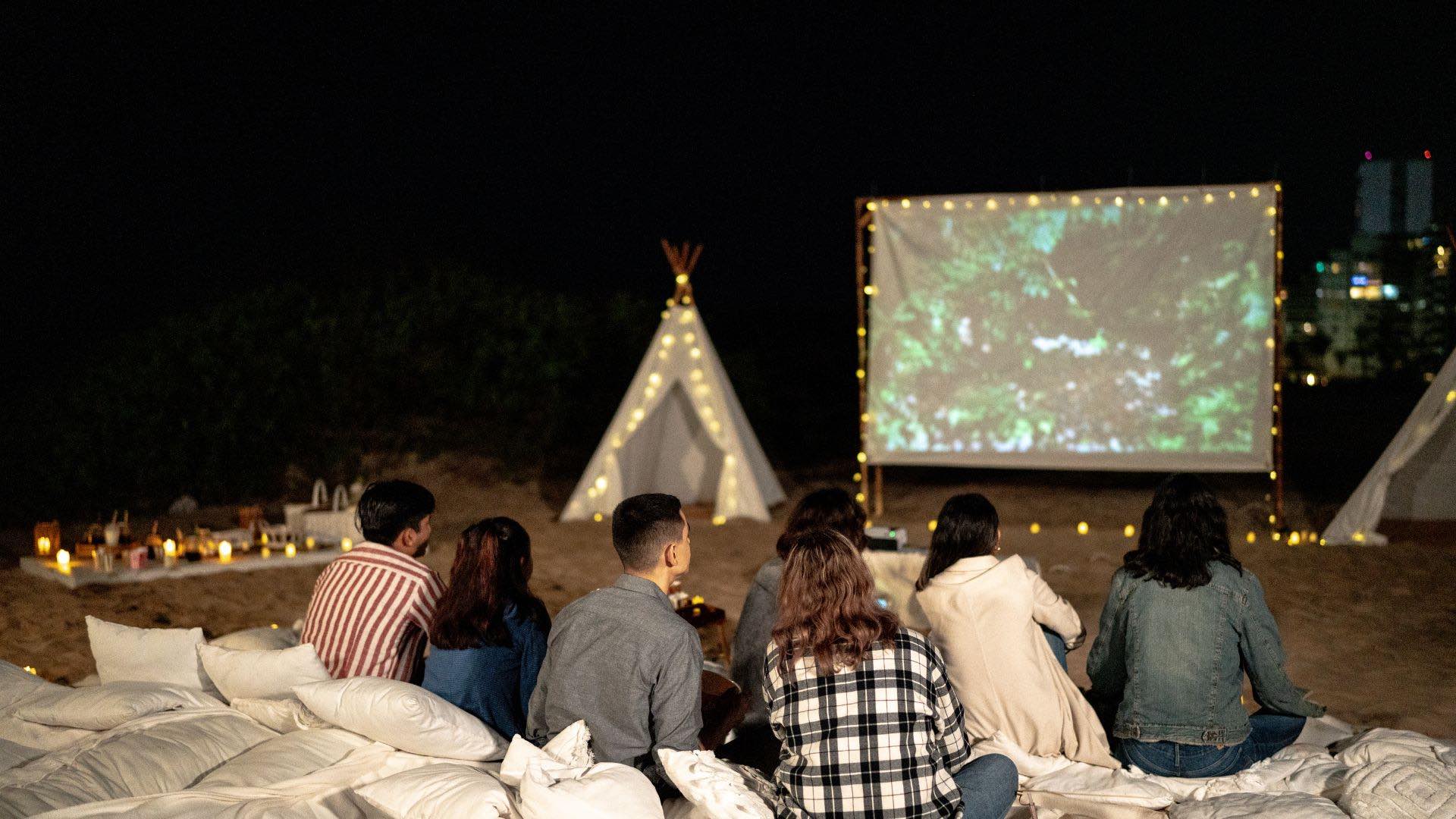 group of friends watching a movie outside