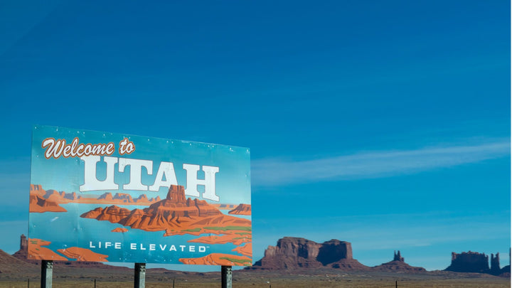 A sign reading "Welcome to Utah Life Elevated in a desert