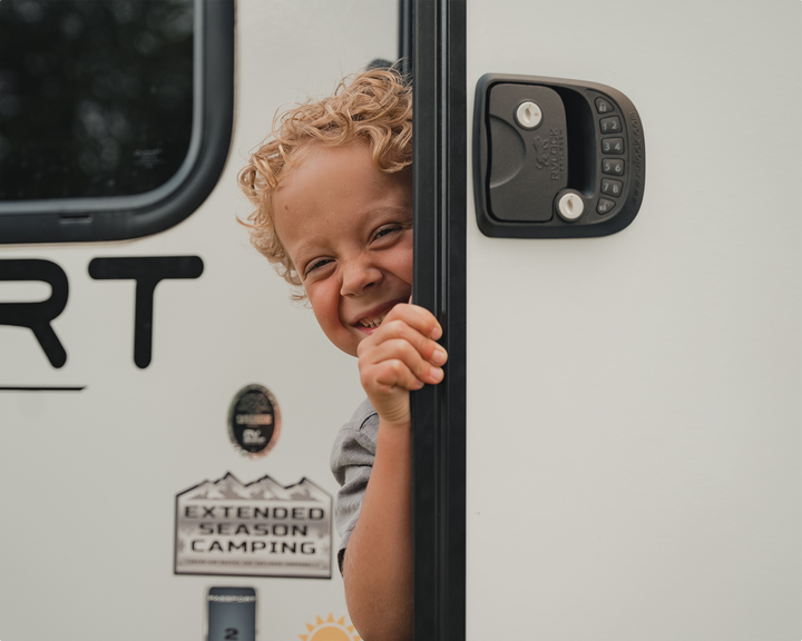 boy hiding behind trailer door with keyless rvlock handle